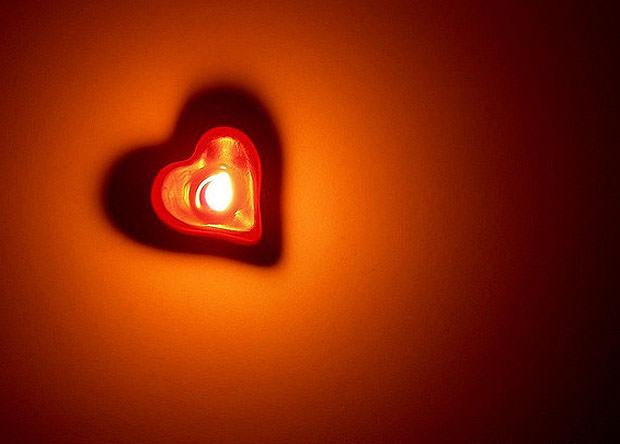 Candle casting a heart shaped shadow