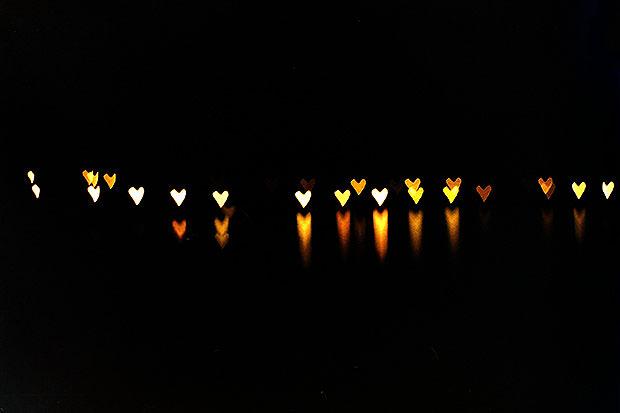 Orange heart shape lights with reflections in water