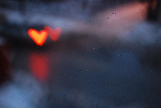 Single red heart light through a window