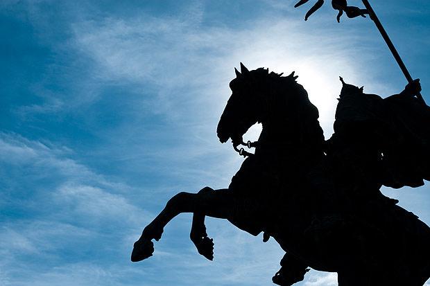 Horse statue silhouetted against a blue sky