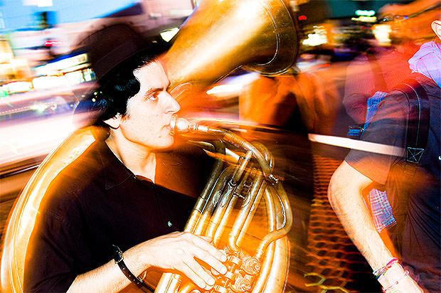 Slow sync flash photo of a man playing a French horn