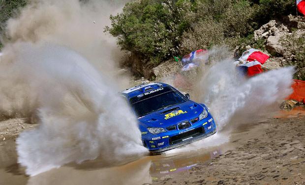 Subaru rally car racing through water